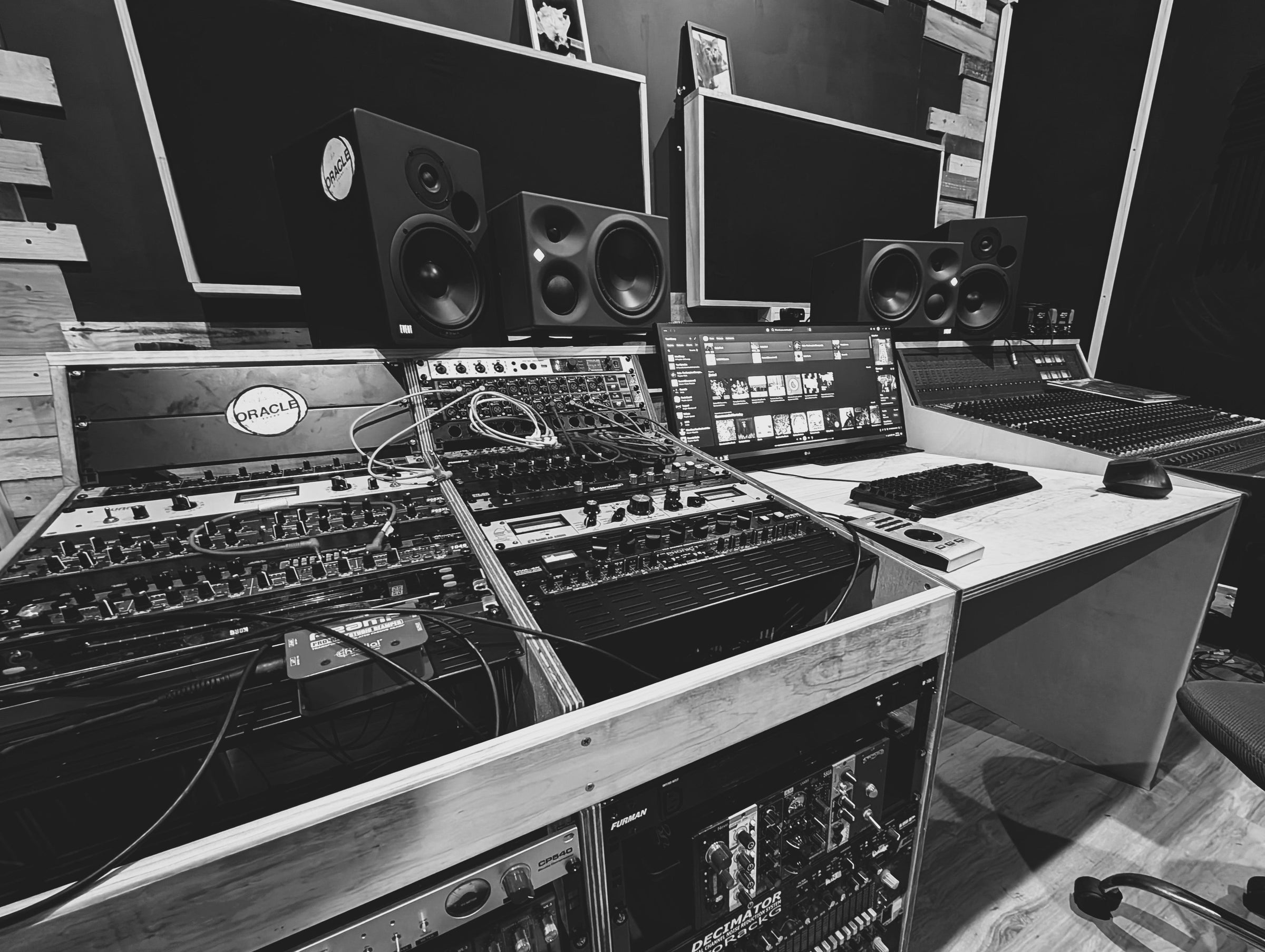 Studio control room with mixing console, monitors, and equipment.